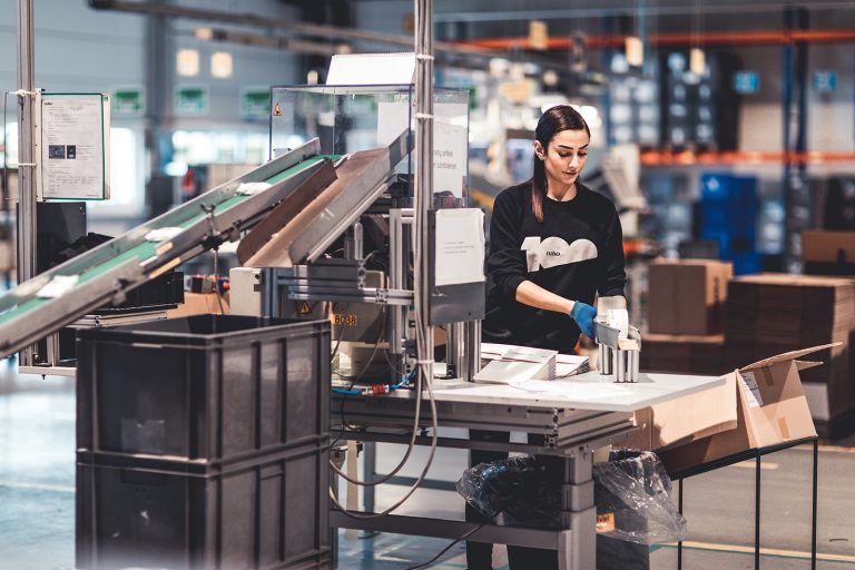 Vrouwelijke productiemedewerker aan het werk in een productieruimte.